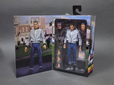 une boîte sur laquelle figure la photo d'un homme en chemise blanche et en jean
