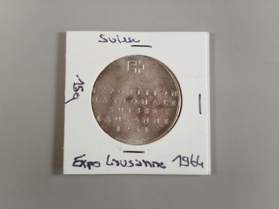 un gros plan d'une pièce de monnaie posée sur une surface blanche, sur laquelle figurent des inscriptions
