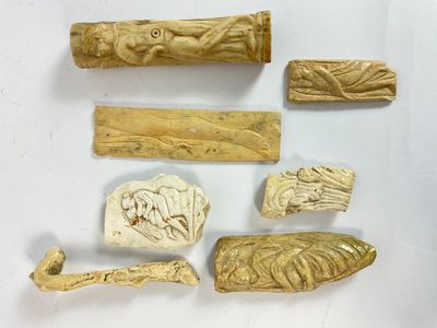 Plusieurs pièces de bois sculpté sont exposées sur un fond blanc