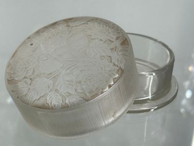 un bocal en verre muni d'un couvercle orné d'un motif floral