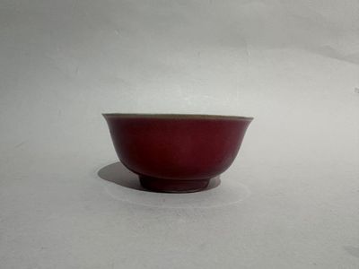 a small red bowl sitting on a white surface