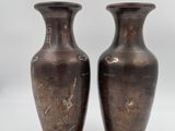 pair of antique bronze vases on wooden bases on a white background