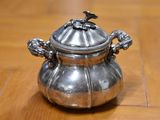 a silver pot sitting on a wooden table
