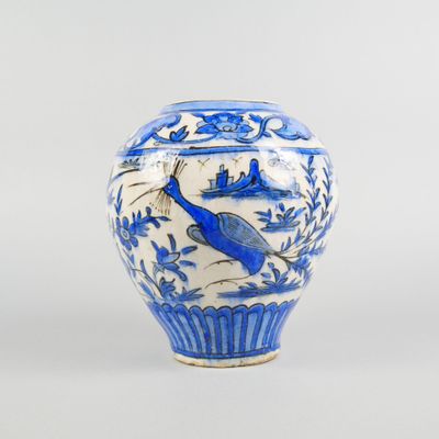 a blue and white vase with a bird on it