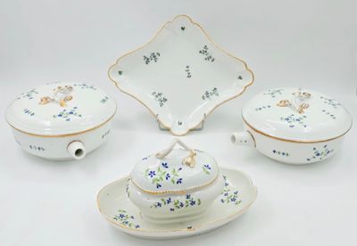 a white plate with blue flowers on it next to a bowl and a plate with a lid