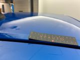 the sticker is on the hood of a blue sports car
