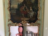 a large mirror with a painting on it in a room