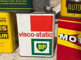 three cans of motor oil sitting on the ground