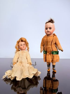 two dolls sitting next to each other on a table