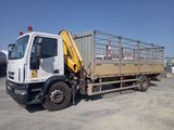 un camion équipé d'une cage à l'arrière, garé sur un parking