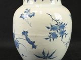 a blue and white vase sitting on a black surface