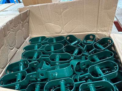 une boîte remplie de pièces en plastique vert, elle-même placée dans une boîte