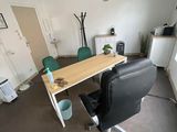 un bureau et une chaise dans une pièce où est accrochée une horloge au mur