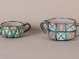 two small cups are sitting next to each other on a table