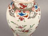 a vase with a lid that has flowers and birds on it