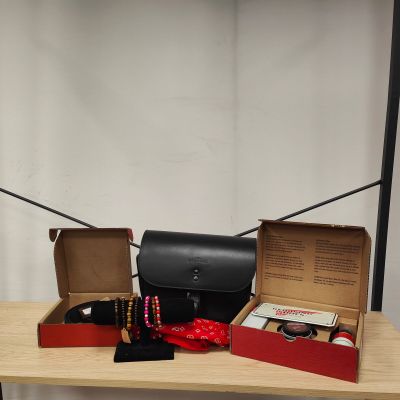 deux boîtes posées sur une table, sur laquelle se trouvent un sac à main et d'autres objets