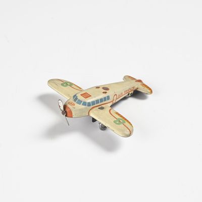 un petit avion miniature posé sur une surface blanche