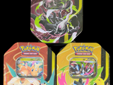 On voit trois boîtes de cartes à collectionner Pokémon sur un fond noir.