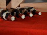 bottles of wine are lined up on a red table cloth
