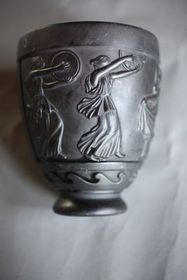 un vase en argent orné d'un motif sur fond blanc