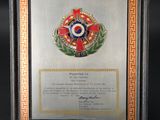 an image of a framed picture of a medal and a certificate