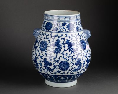 a blue and white vase with a flower design on it