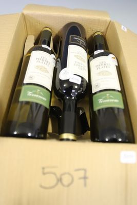 four bottles of wine in a cardboard box on a table