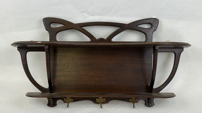 a wooden shelf that has a cat head on it