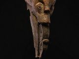 a carved head of an elephant on a wooden stand