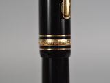 a close up of a fountain pen with a gold trim