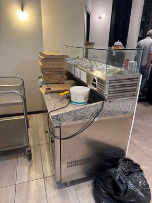 une photo d'un comptoir sur lequel sont posées plusieurs pizzas