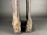 pair of silver boots on a gray surface with a gray background