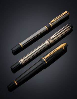 three different types of fountain pens on a black background