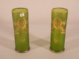 pair of green vases with gold designs on them sitting on a white surface