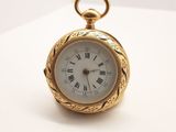 une image d'une montre de poche en or avec des chiffres romains sur le cadran