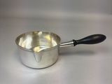 une casserole argentée avec une poignée noire sur un fond blanc