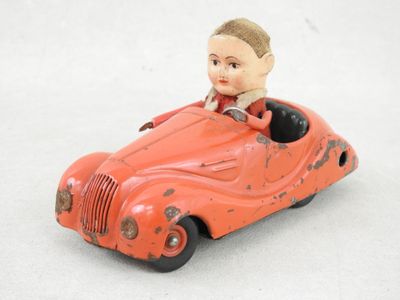 une petite voiture rouge avec un petit garçon à l'intérieur