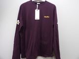 a close up of a purple shirt with a tag on it