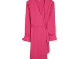 une robe rose à volants suspendue à un cintre sur un mur blanc