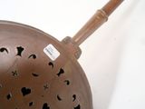 a large metal bowl with a wooden handle on a white surface