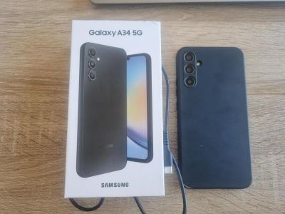 une photo montrant une boîte de Samsung Galaxy S5e posée à côté d'un ordinateur portable sur une table