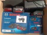 Des boîtes d'outils électriques Bosch sont posées sur un carton.