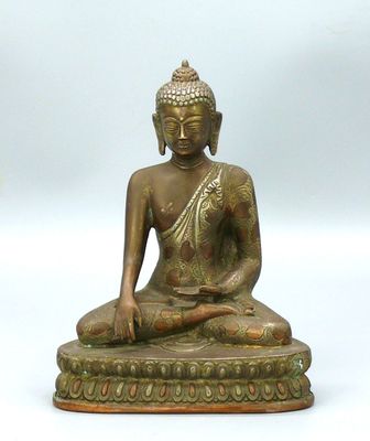 statue en bronze représentant une personne assise sur une estrade