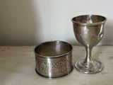 a silver cup sitting next to a silver cup on a table