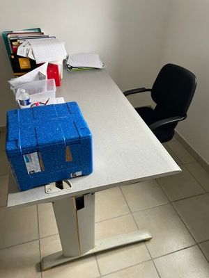 a blue box sitting on top of a white table next to a black chair