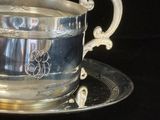 une tasse et une soucoupe en argent posées sur un plateau en argent