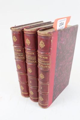 quatre livres rouges sont empilés les uns sur les autres sur une surface blanche