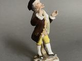 a figurine of a man with a hat and yellow pants