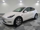 un SUV Tesla blanc garé dans un garage dont le sol est en damier
