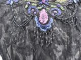an image of a woman wearing a black dress with purple and blue flowers on it